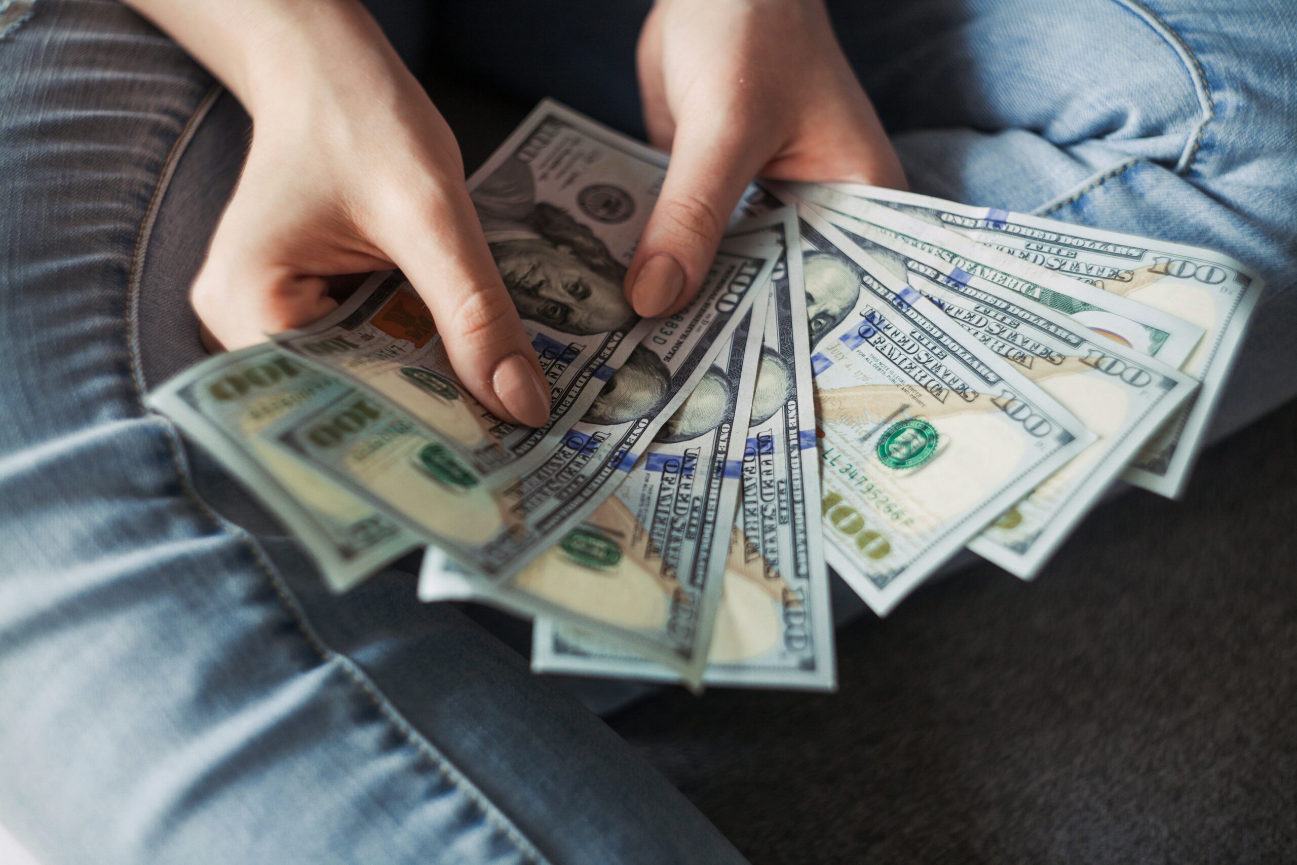 Person counting money for trip budget