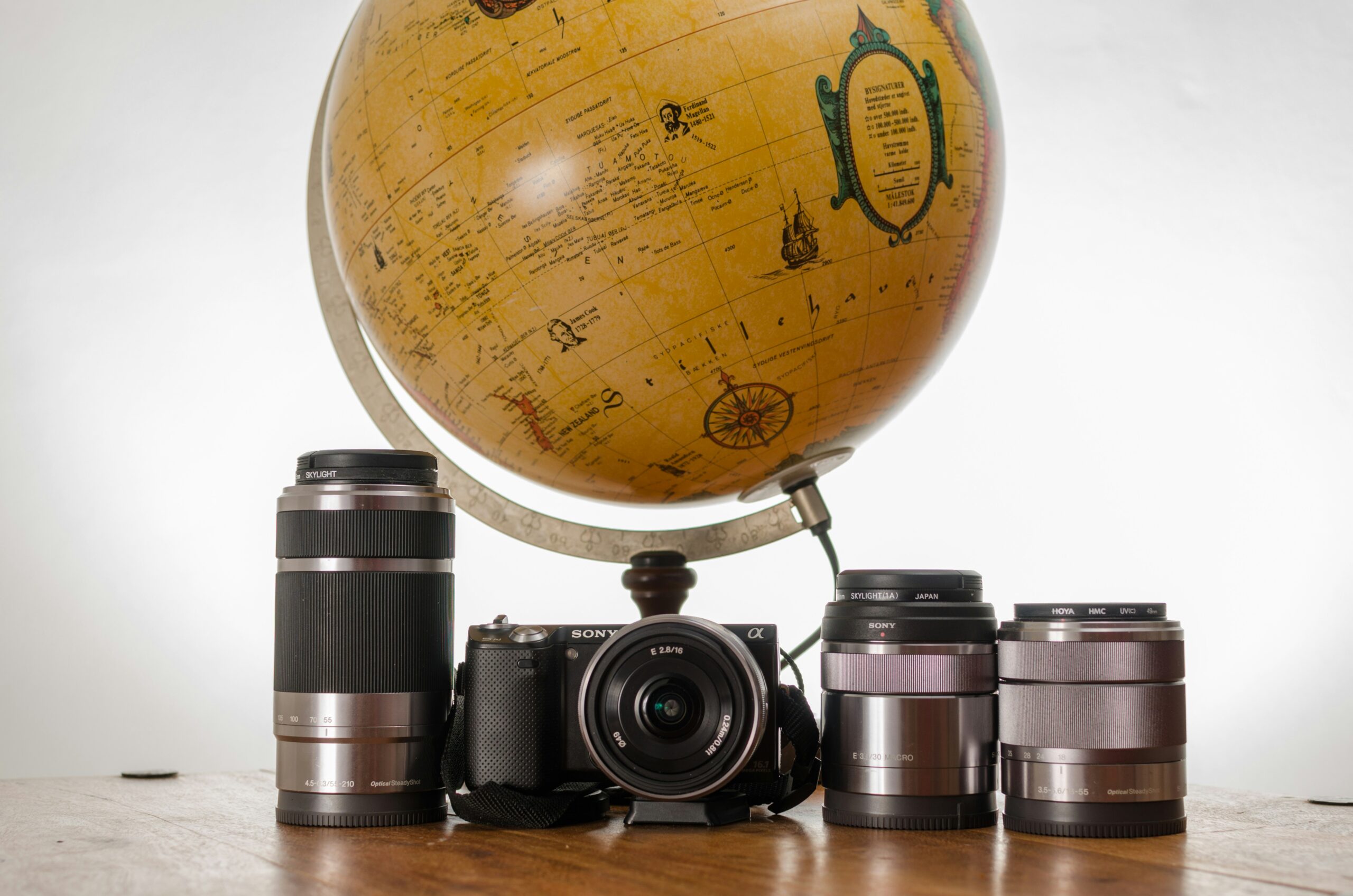 World globe placed next to a collection of cameras symbolizing travel and photography