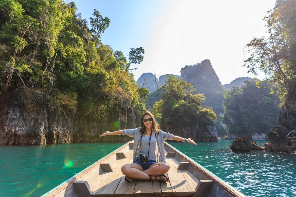 Manali tourist place with woman on boat surrounded by hills and trees