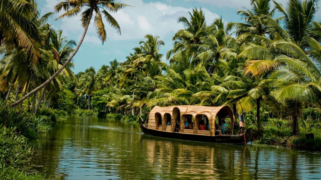Backwater ripples Kumarakom with houseboat and coconut trees